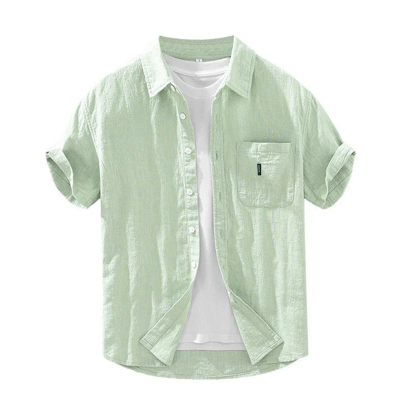 Light green short-sleeve linen shirt with rolled cuffs and front pocket over white t-shirt