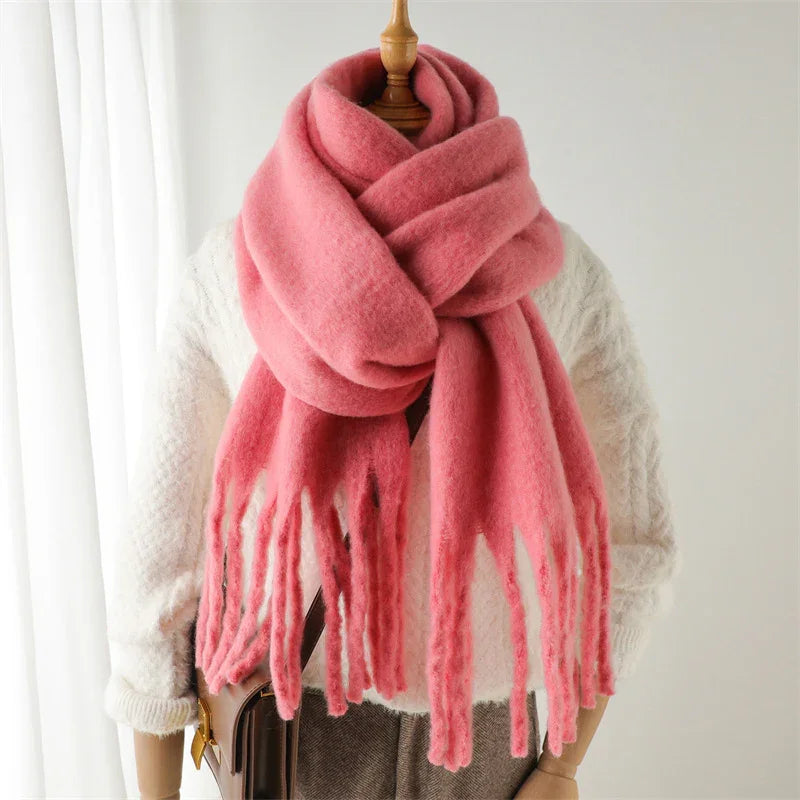 Soft pink wool scarf with fringes on mannequin wearing white knit sweater and brown bag