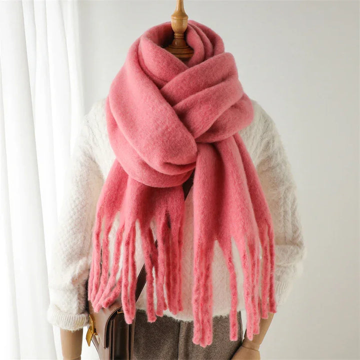 Soft pink wool scarf with fringes on mannequin wearing white knit sweater and brown bag