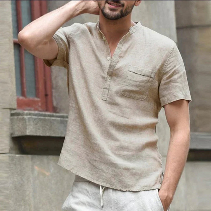 Man wearing casual light beige short-sleeve linen henley shirt with chest pocket outdoors