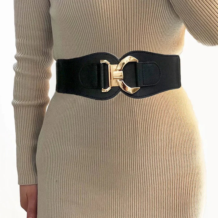 Close-up of a black wide belt with gold buckle worn over beige ribbed knit dress