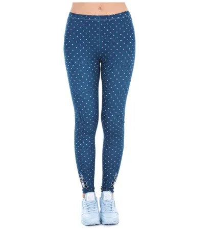 Woman wearing blue leggings with small white polka dots and white sneakers