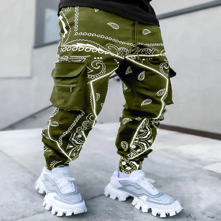 Men's cargo pants with olive green bandana print paired with chunky white sneakers on concrete floor
