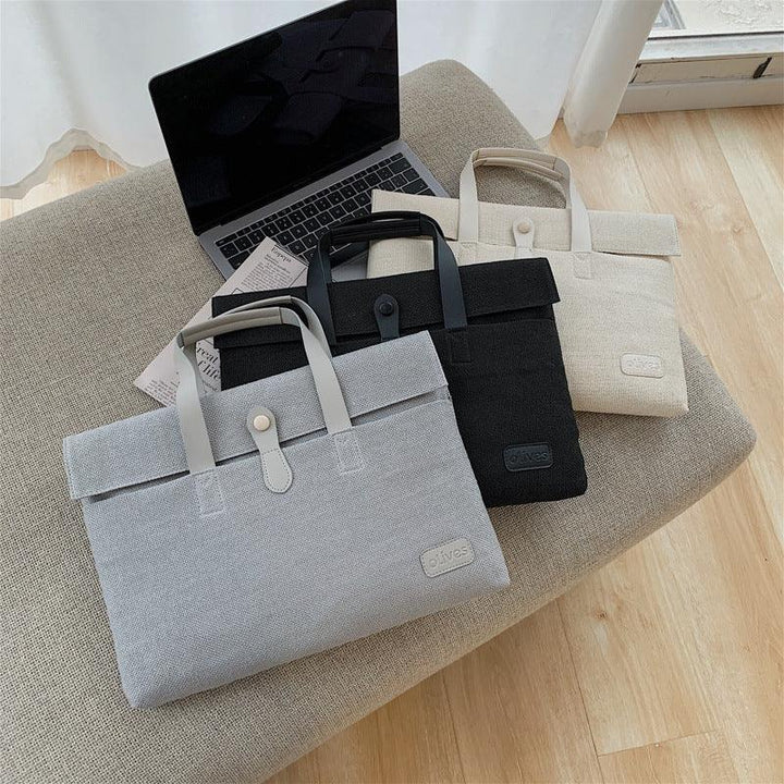 Three stylish laptop bags in gray, black, and beige on a beige ottoman next to an open laptop