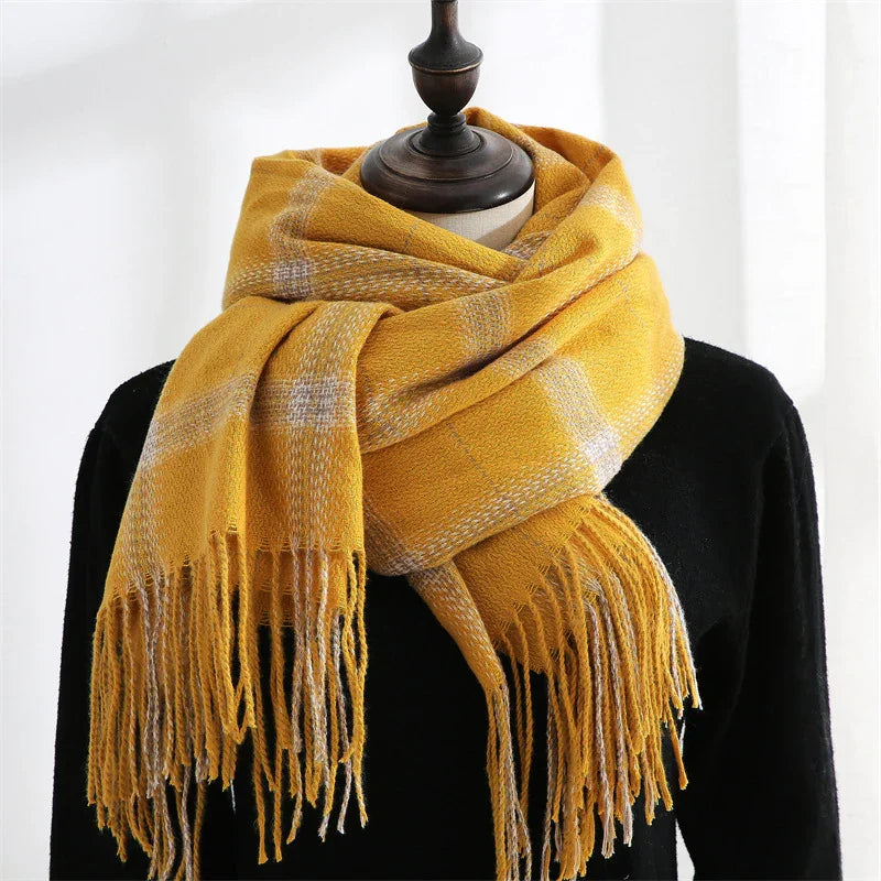 Yellow plaid fringed scarf wrapped on black mannequin bust against white background