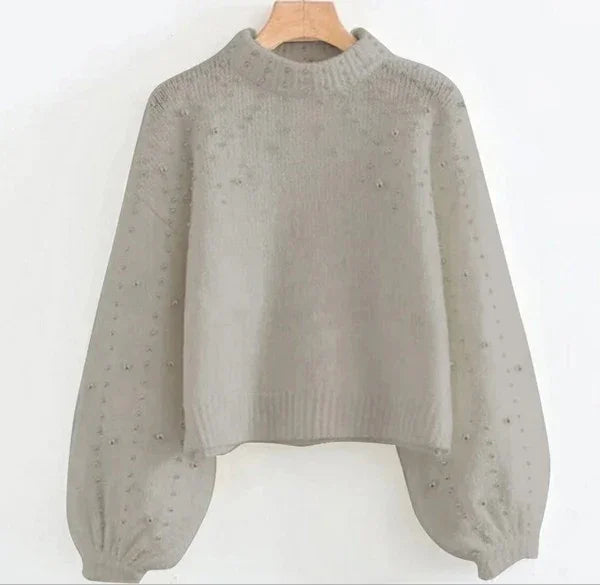 Light grey knit sweater with balloon sleeves and textured pearl accents on a wooden hanger