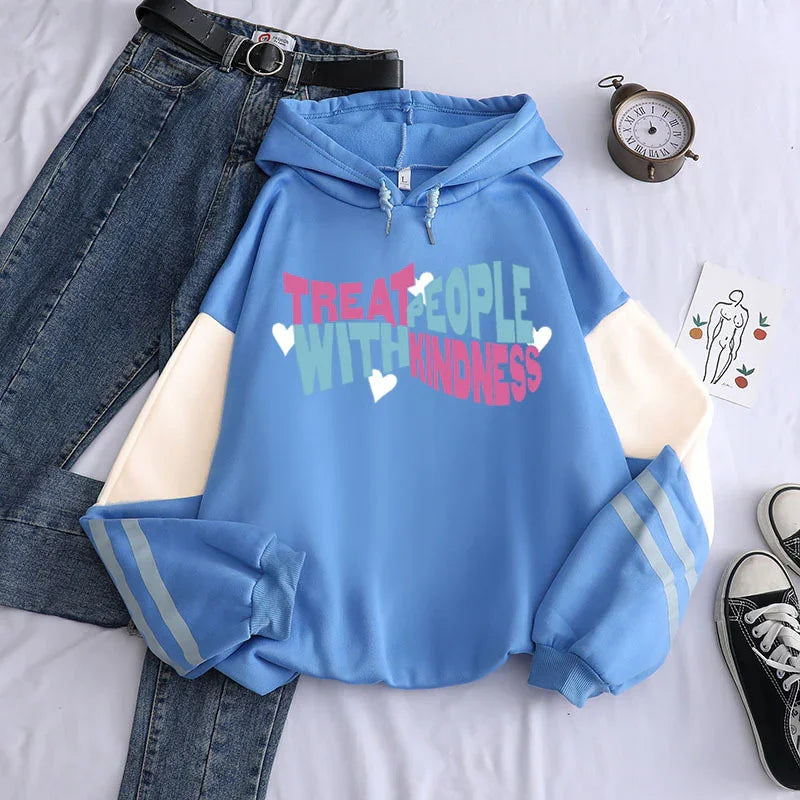Casual outfit featuring blue hoodie with kindness message, light sleeves, paired with denim jeans and black sneakers