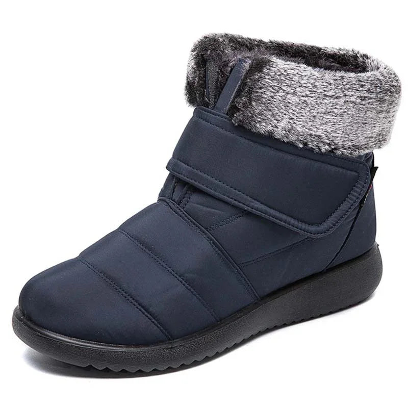 Navy blue winter boot with black sole and gray faux fur cuff, padded and insulated