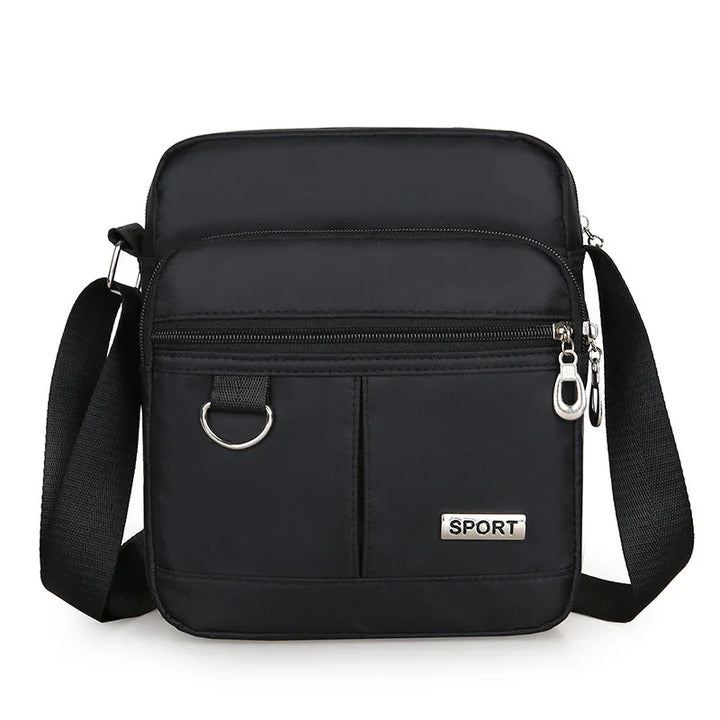 Black sport crossbody bag with adjustable strap, front zipper pockets, and silver hardware