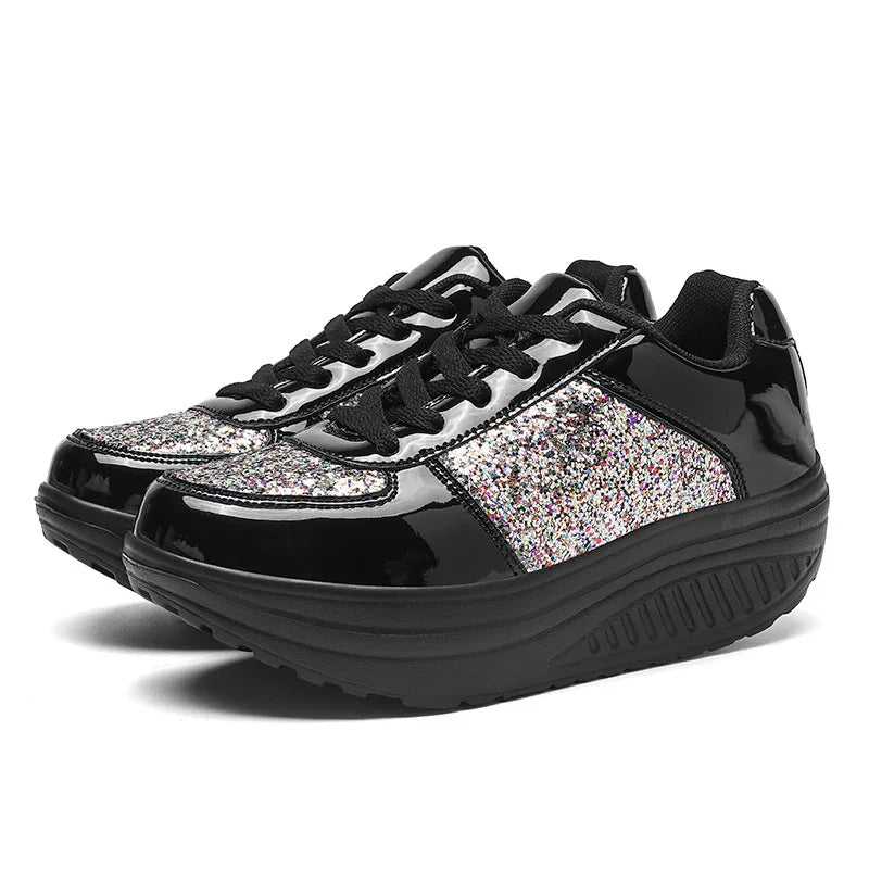 Pair of black platform sneakers with glittery silver accents and thick cushioned soles