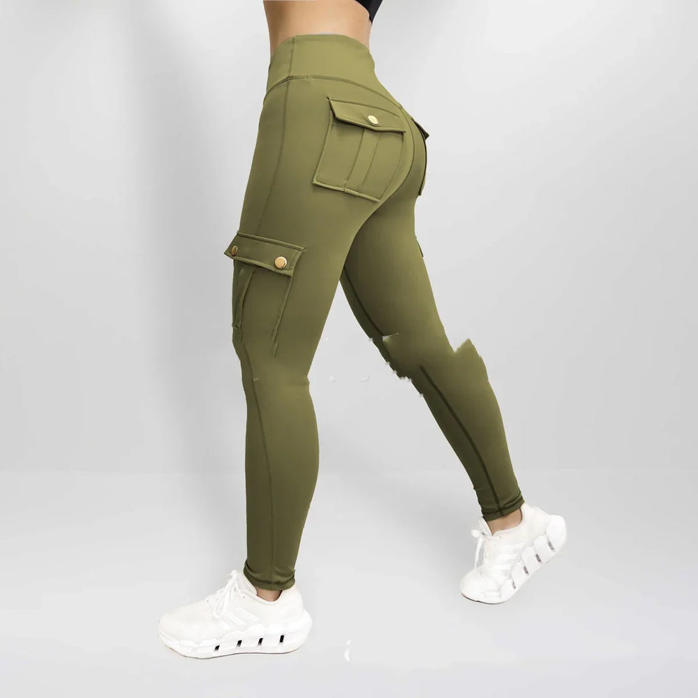 Side view of woman wearing olive green high-waisted cargo leggings with flap pockets and white sneakers
