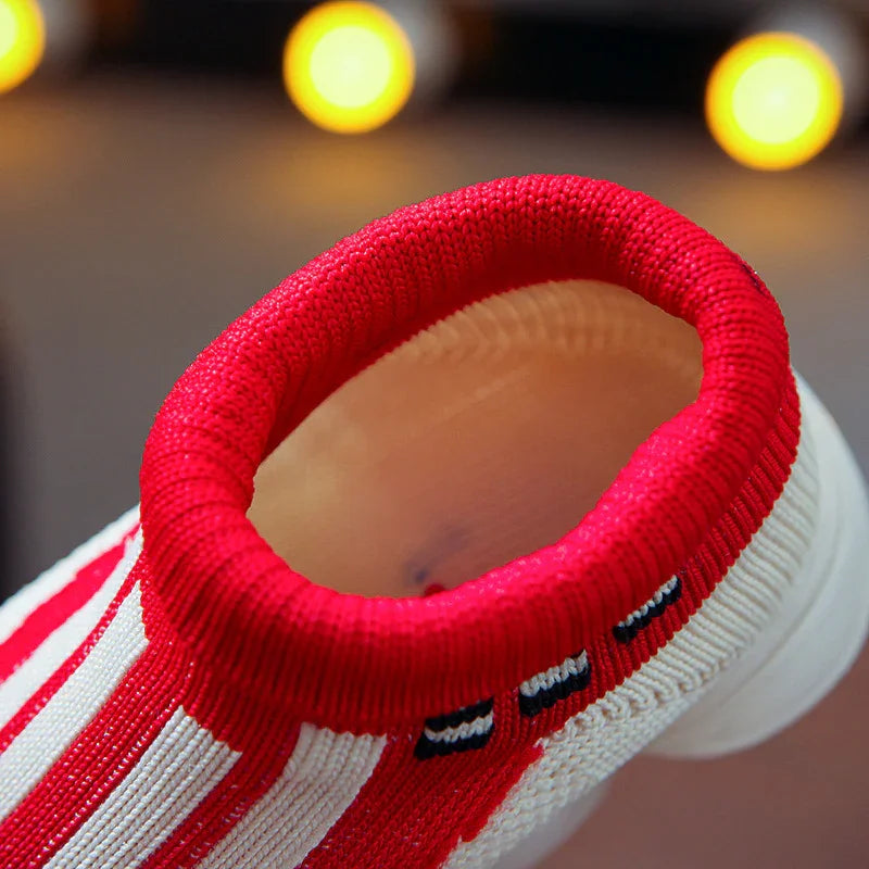 Close-up of a red and white striped knit sock with a red cuff and black embroidered details