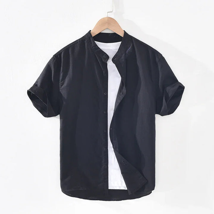 Black short-sleeve button-up shirt layered over white t-shirt on wooden hanger against white background