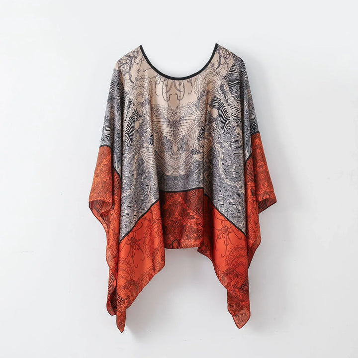 Bohemian flowy tunic top with intricate black patterns on beige and red fabric, hanging on wall