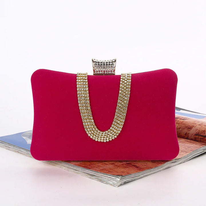 Elegant red velvet clutch bag with gold rhinestone chain and jeweled clasp on magazine