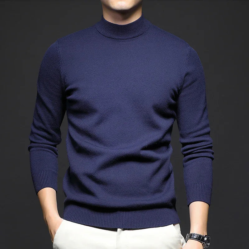 man wearing fitted navy blue turtleneck sweater with white pants and black wristwatch
