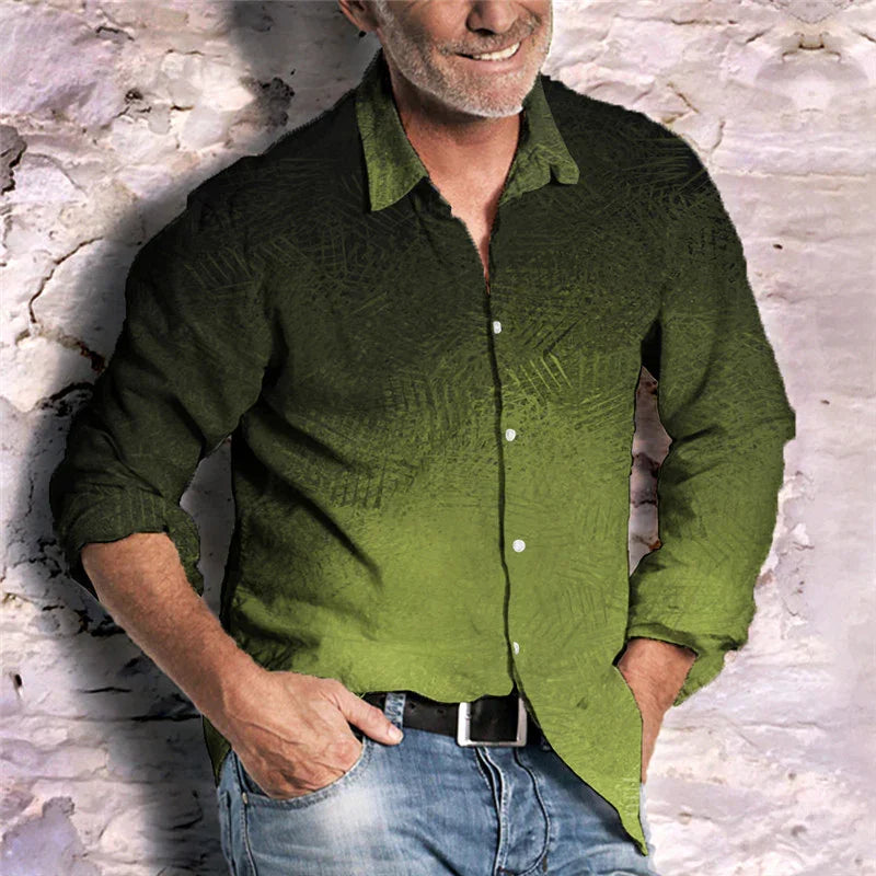Man wearing green ombre button-up shirt with subtle leaf pattern, paired with blue jeans, standing against textured white wall