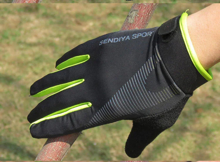 Black and neon green SENDIYA SPORT glove gripping a tree branch outdoors
