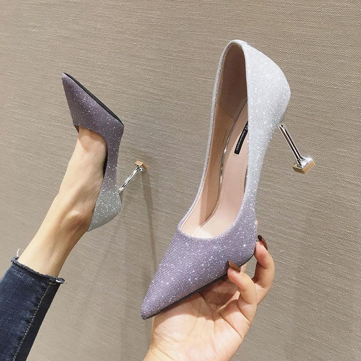 Pair of glittery pointed-toe high heels with unique metallic geometric heels on beige background