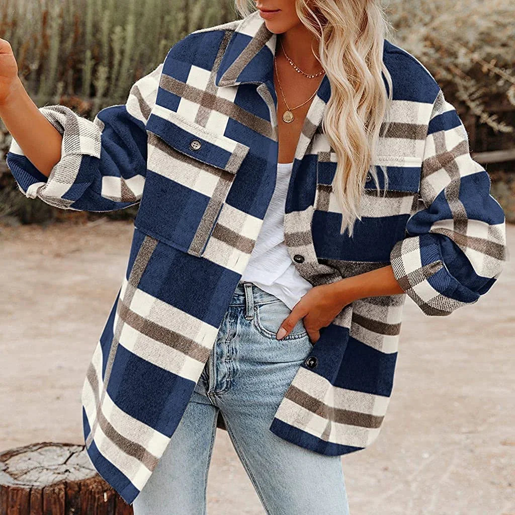 Woman wearing oversized blue and beige plaid jacket with rolled sleeves and light wash jeans outdoors