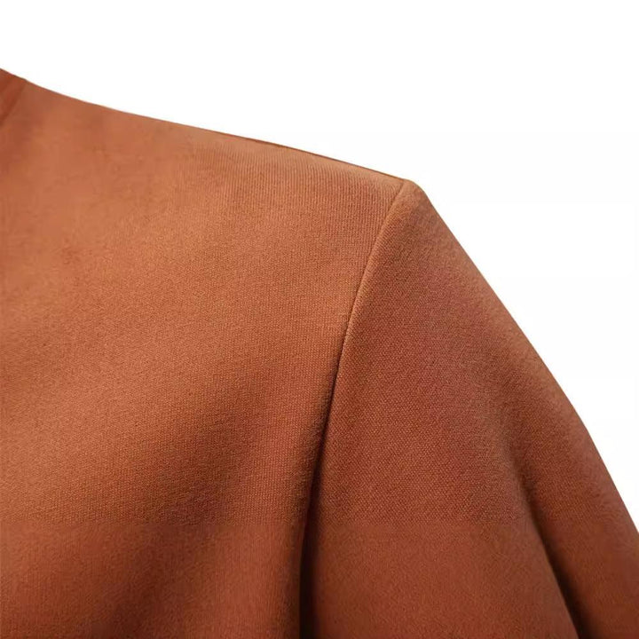 Close-up of brown fabric shoulder seam on a garment against white background