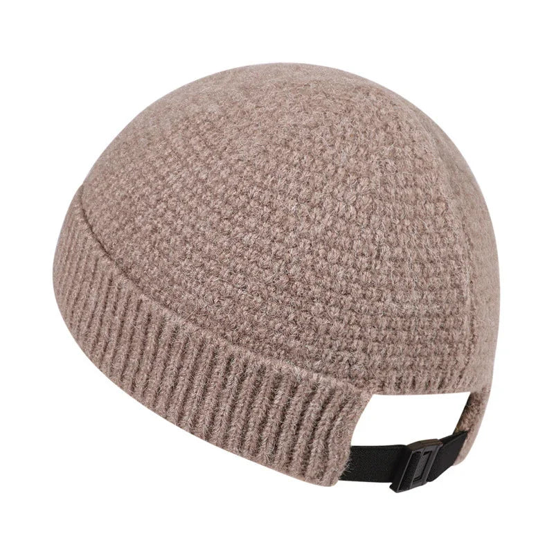 Beige textured knit winter beanie hat with adjustable black strap on white background