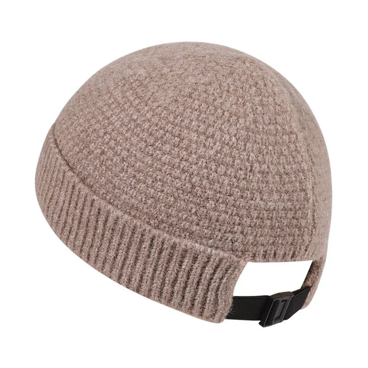 Beige textured knit winter beanie hat with adjustable black strap on white background