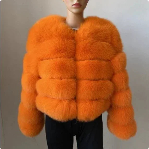 Woman wearing vibrant orange fluffy faux fur jacket against neutral background