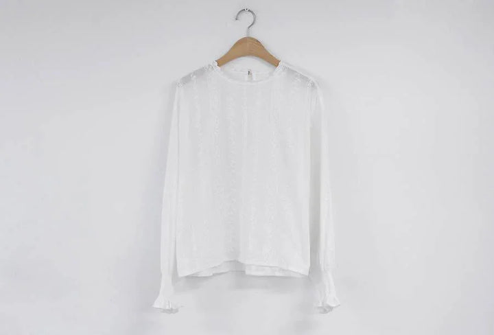 White long-sleeve lace blouse with ruffled cuffs on wooden hanger against plain white wall