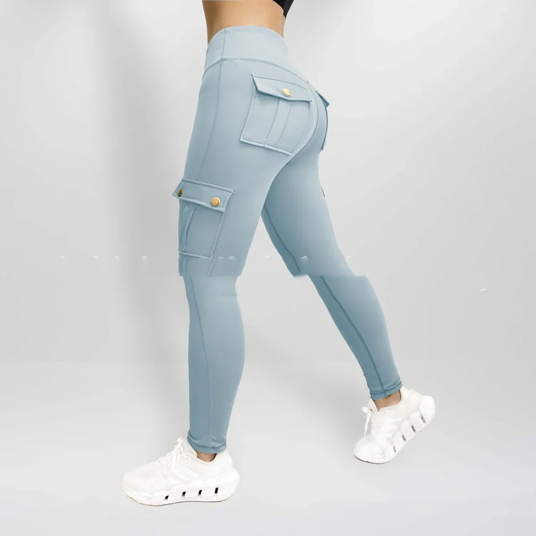 Woman wearing light blue high-waisted cargo leggings with snap button pockets and white sneakers