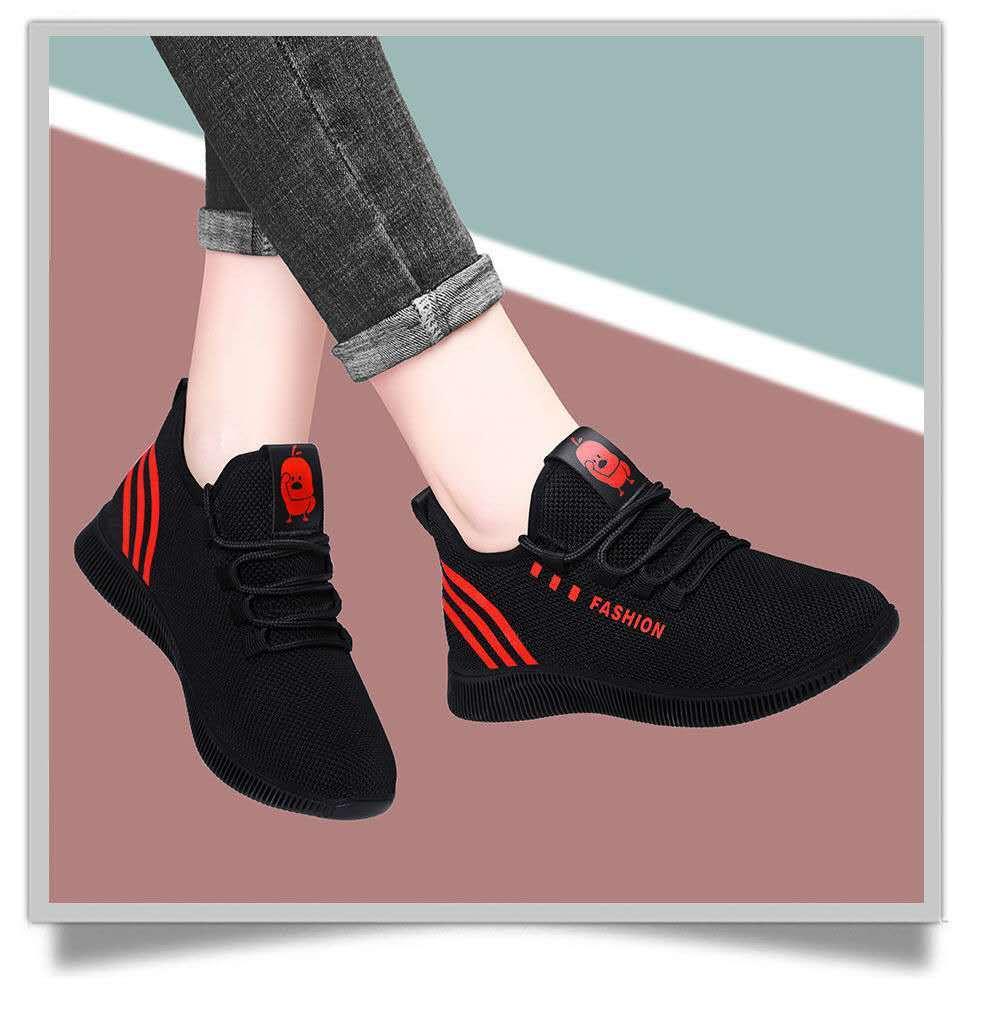 Black and red fashion sneakers with mesh upper and cartoon logo worn with rolled up jeans
