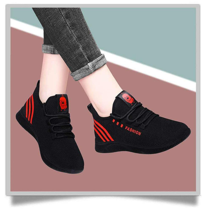 Black and red fashion sneakers with mesh upper and cartoon logo worn with rolled up jeans