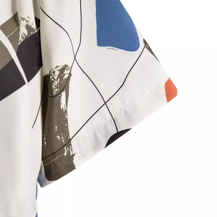 Close-up of white fabric sleeve with abstract geometric blue, brown, black, and orange print and black line details