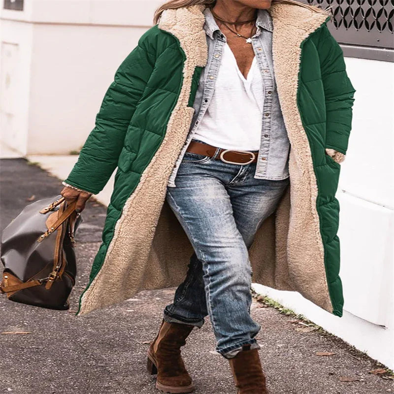 Woman wearing green sherpa-lined quilted coat with denim shirt, white top, jeans, brown boots, and carrying brown handbag