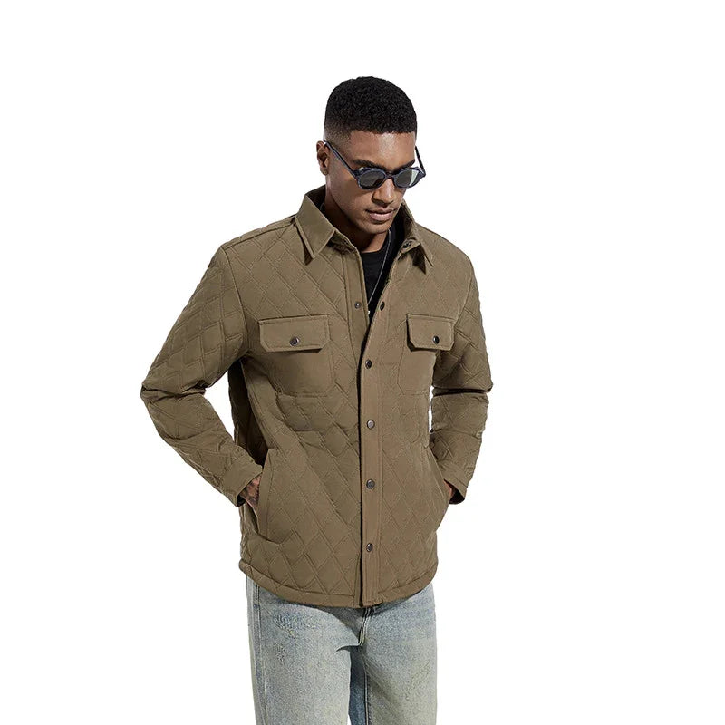man wearing quilted olive green jacket with flap pockets and blue jeans on white background