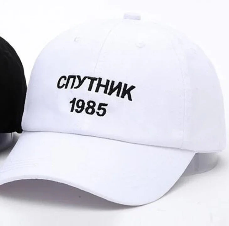 White baseball cap with black embroidered text 'СПУТНИК 1985' on front panel