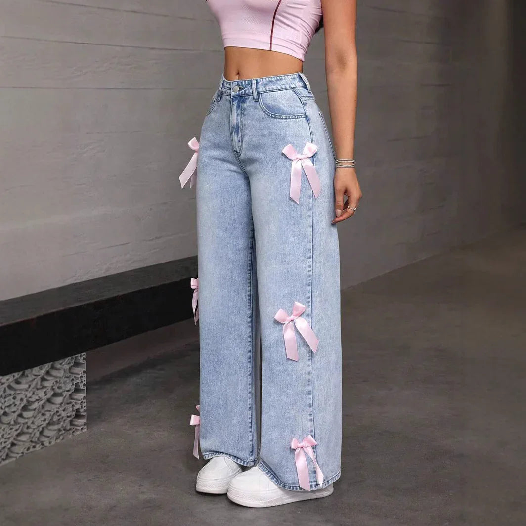 Light blue wide-leg jeans with pink satin bows paired with white sneakers and pink crop top