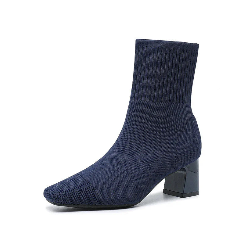 Navy blue knit ankle boot with block heel and ribbed cuff on white background
