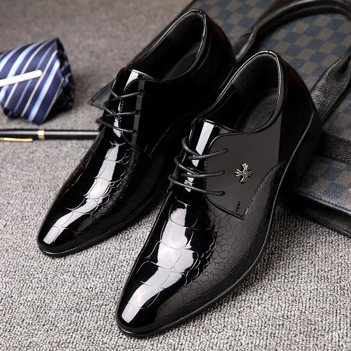 Glossy black men's dress shoes with laces and reptile texture detail on gray carpet