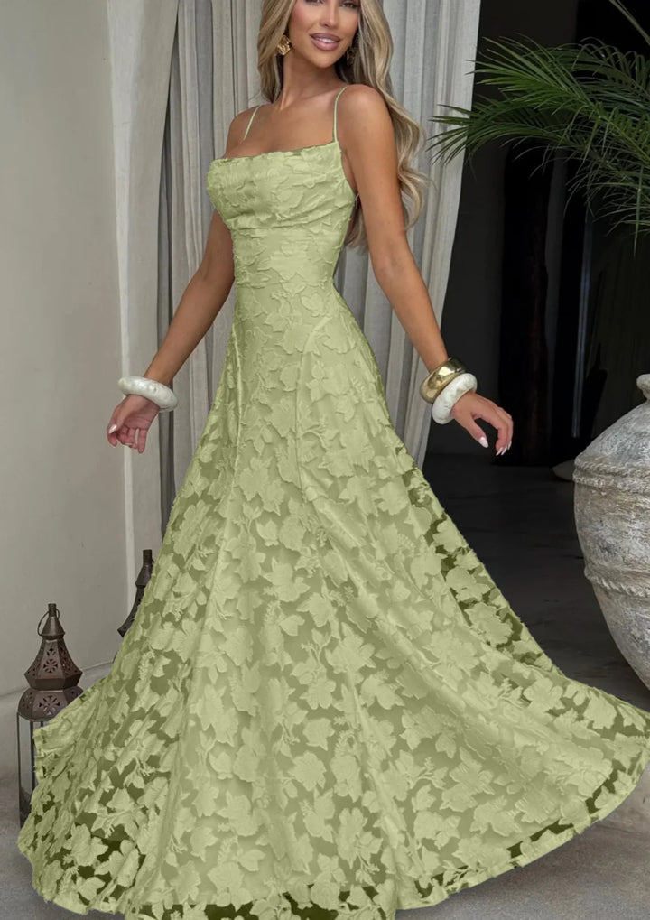 Woman in sleeveless green floral lace evening gown with bracelets, indoor elegant setting