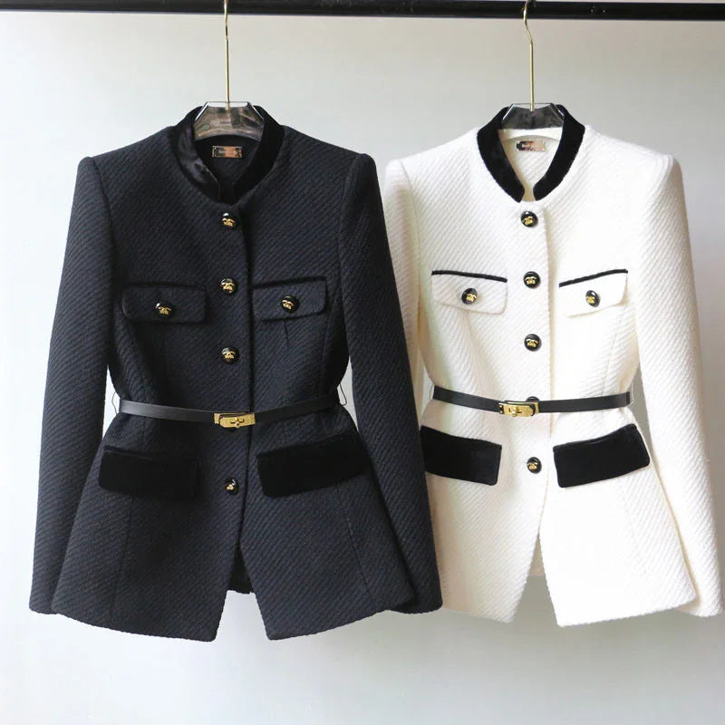Elegant black and white tailored blazers with gold buttons and black belts, hanging on hangers