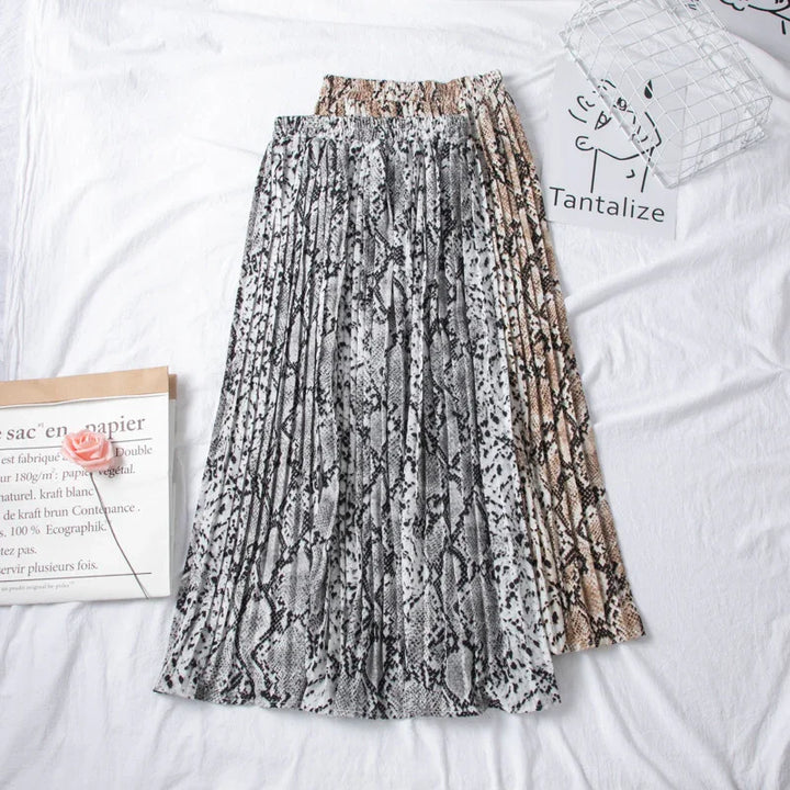 Two pleated skirts with snake print patterns in grey and brown shades on white background