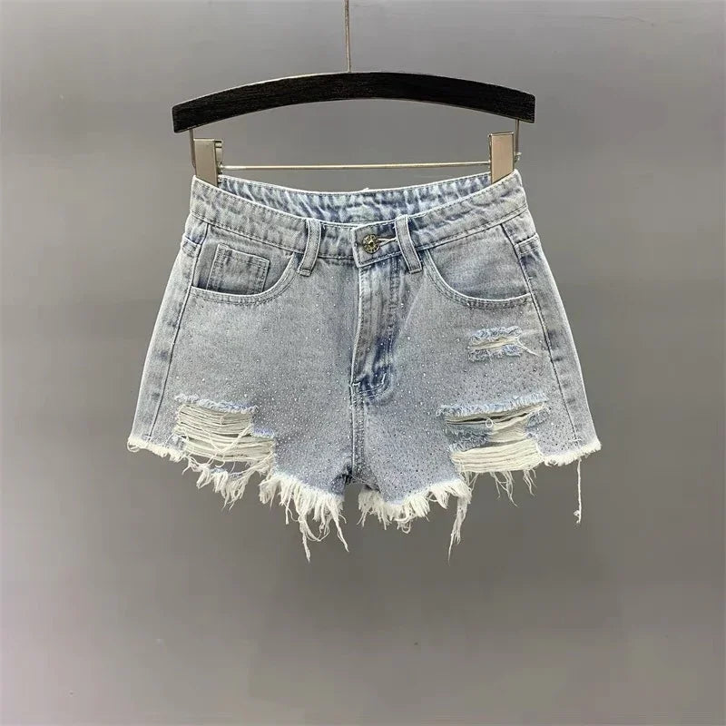 Light wash distressed denim shorts with frayed hems hanging on black hanger