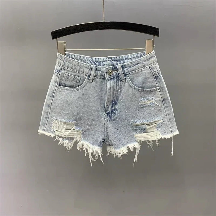 Light wash distressed denim shorts with frayed hems hanging on black hanger