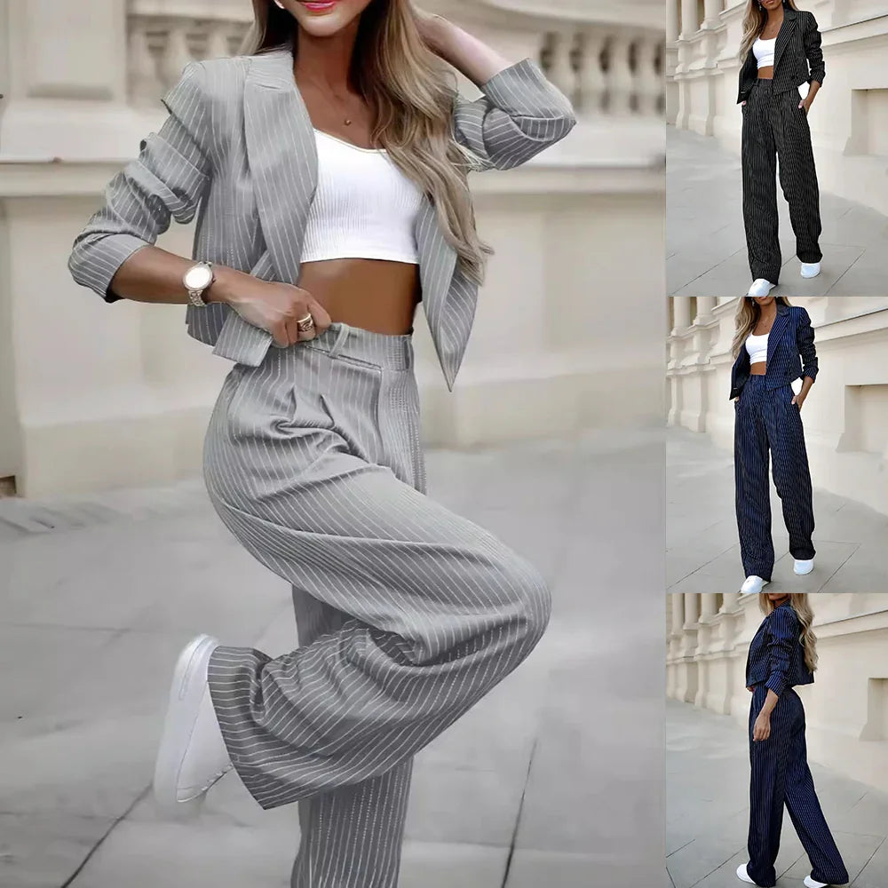 Woman wearing pinstripe blazer and matching wide-leg pants with white crop top and sneakers in urban setting