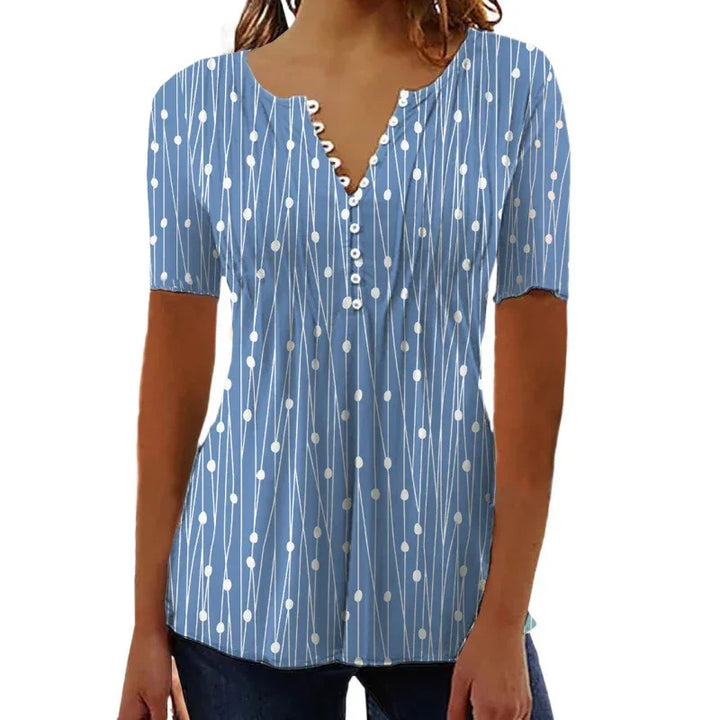 Woman wearing blue short-sleeve blouse with white dotted line pattern and buttoned V-neck