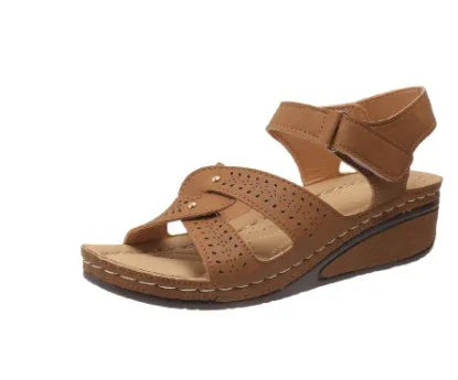 Brown leather women's wedge sandal with perforated design and adjustable ankle strap