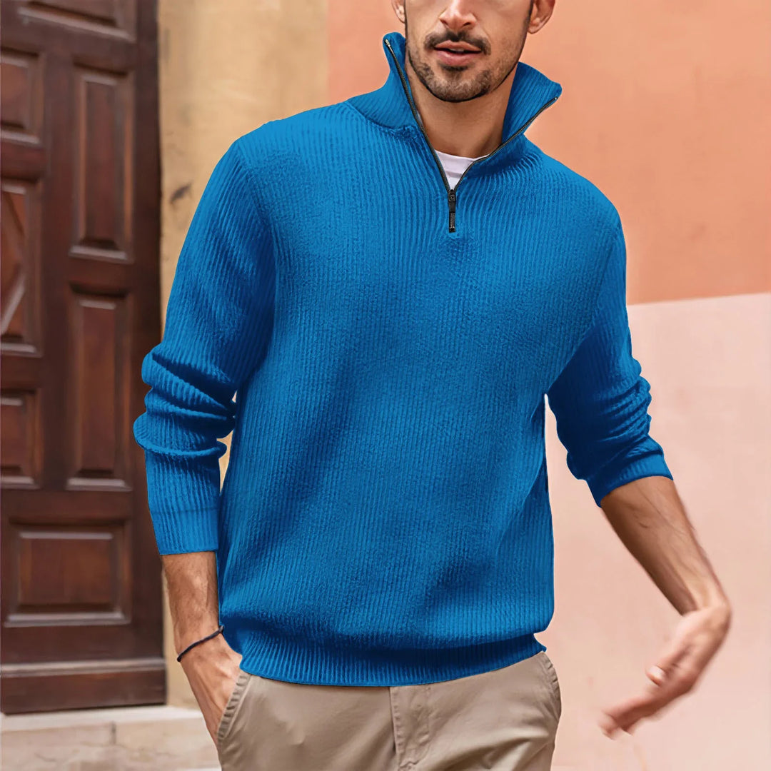 Man wearing bright blue ribbed quarter-zip sweater with beige pants in outdoor setting