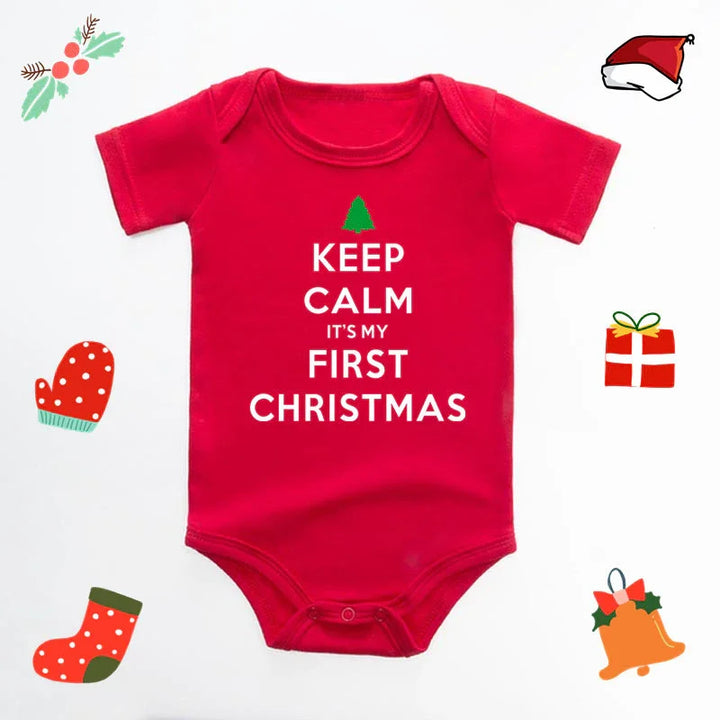 Red baby onesie with white text "Keep Calm It's My First Christmas" surrounded by Christmas themed icons