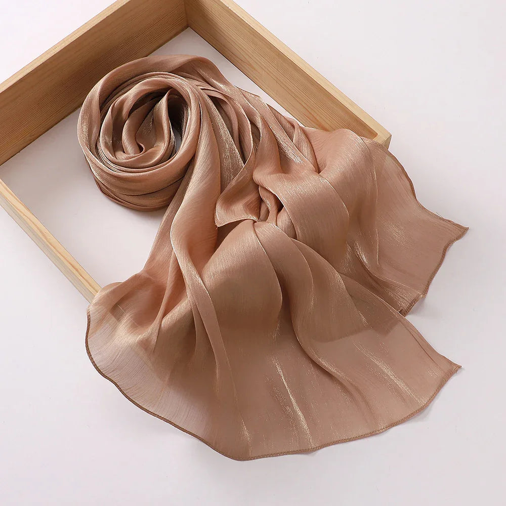 Elegant light brown sheer satin scarf displayed in a wooden tray on white background